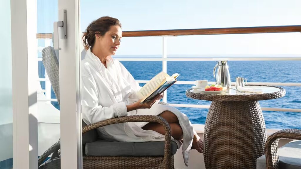 suites-and-staterooms-upgrade-your-experience-consierge-veranda-gallery-736x520-guest-reading-on-veranda-balcony.avif